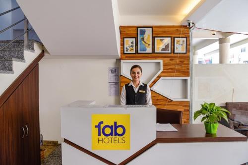 a man standing behind a desk in an office at FabHotel Surbhi in Bhopal