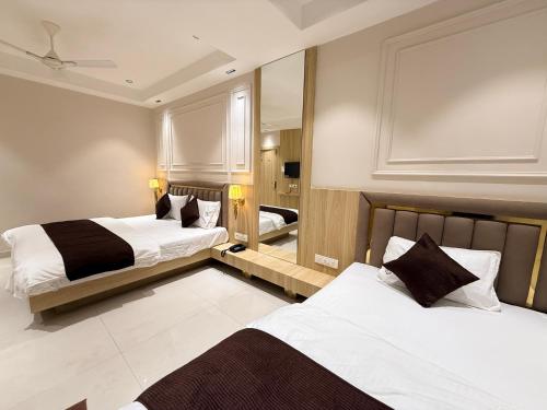 Una habitación de hotel con dos camas y un espejo. en Hotel RK Residency, en Ujjain