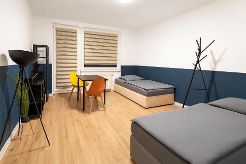 a bedroom with a bed and a table and a chair at Moderne 3-Zimmer-Ferienwohnung in Emersleben in Halberstadt