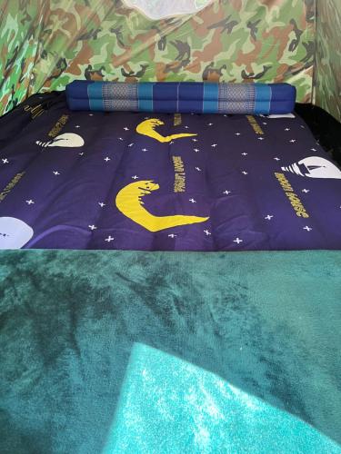 una cama con un edredón morado con un edredón con una cama en Baan Pai Likit, en Pai