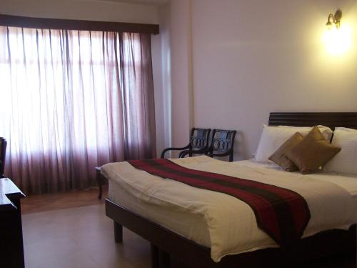 a bedroom with a large bed and a window at Forest Ville Hotel & Resort in Kasauli