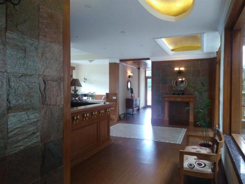 a lobby with a large stone wall and a hallway at Forest Ville Hotel & Resort in Kasauli