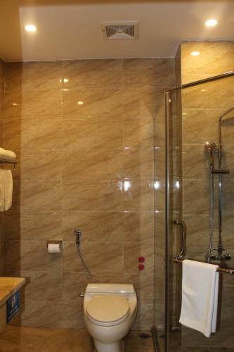 a bathroom with a toilet and a glass shower at Hai Yen Luxury Hotel in Cẩm Phả