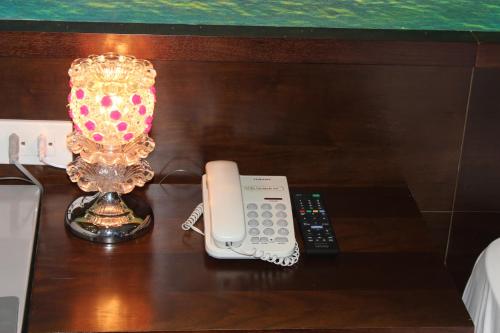 a phone and a lamp on a table at Hai Yen Luxury Hotel in Cẩm Phả