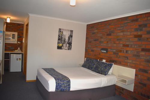 ストーエルにあるCoorrabin Motor Innのレンガの壁とベッドのある寝室