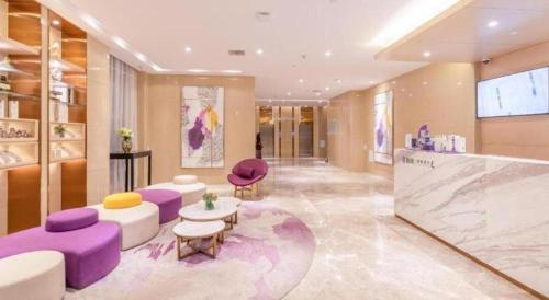 a lobby with purple and white furniture in a building at Lavande Hotel Ji'nan Railway Station Long Distance Bus Terminal in Jinan