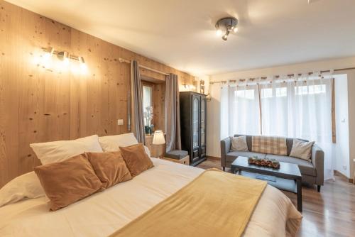 La Tanière في سان جيرفيه ليه بان: غرفة نوم بها سرير كبير وأريكة