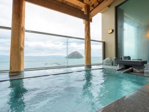an indoor swimming pool with a view of the ocean at Kaisenkaku in Aomori