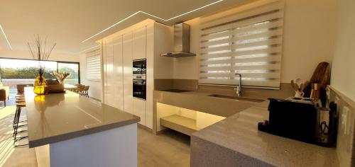 a kitchen with white cabinets and a counter top at Phaedrus Living Venus Seaview Lighthouse Villa in Paphos
