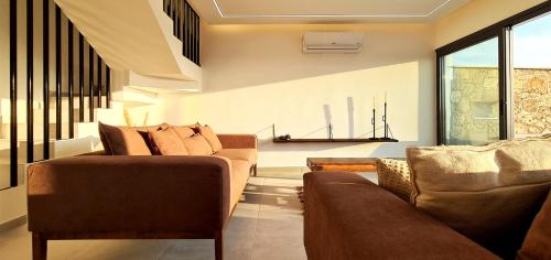 a living room with two brown couches and a window at Phaedrus Living Venus Seaview Lighthouse Villa in Paphos