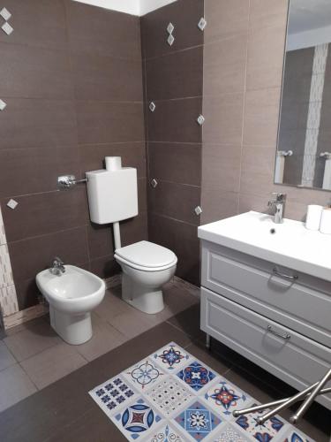 a bathroom with a toilet and a sink and a mirror at La casetta di Sofia in Torino