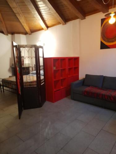 a living room with a couch and a red wall at La casetta di Sofia in Torino