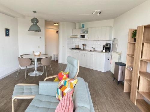 a living room and kitchen with a couch and a table at Residenz Polderblick Burgerbrug in Burgerbrug