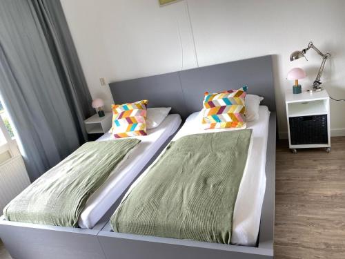 a bedroom with two beds with pillows at Residenz Polderblick Burgerbrug in Burgerbrug
