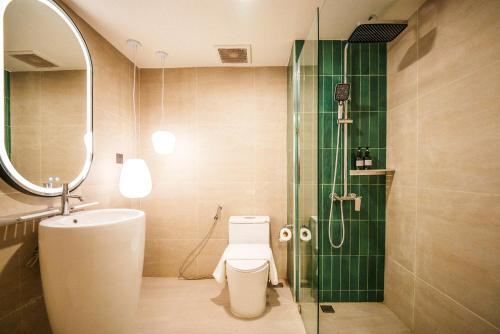 a bathroom with a shower and a toilet and a sink at Palma Hotel in Bangkok