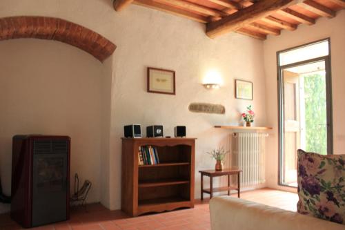 ein Wohnzimmer mit Couch und Kamin in der Unterkunft Il Poggetto in Greve in Chianti