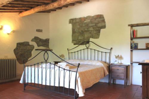 ein Schlafzimmer mit einem Bett und einer Steinwand in der Unterkunft Il Poggetto in Greve in Chianti