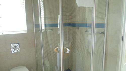 a shower stall with a toilet in a bathroom at Avocet Cottage in Knysna
