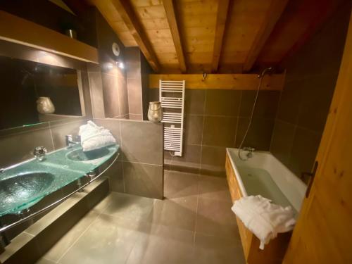La salle de bains est pourvue d'un lavabo vert et d'une baignoire. dans l'établissement Grand Chalet Éden 12 personnes st martin de Belleville 3 vallées, à Béranger