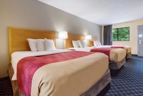 een hotelkamer met twee bedden met rode lakens bij Econo Lodge Battleboro - Rocky Mount I-95 in Battleboro