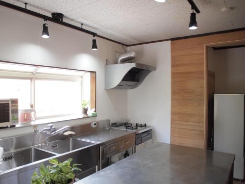 una cocina con fregadero y refrigerador en Lake&Mountain Hamamatsu inn, en Hamamatsu