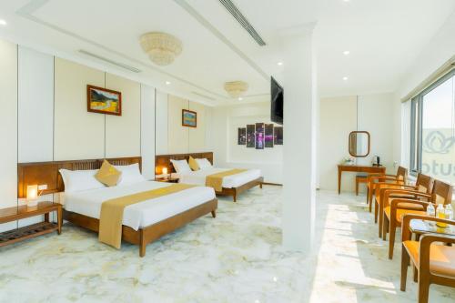 a hotel room with two beds and chairs at Lotus 68 Hotel in Ninh Binh