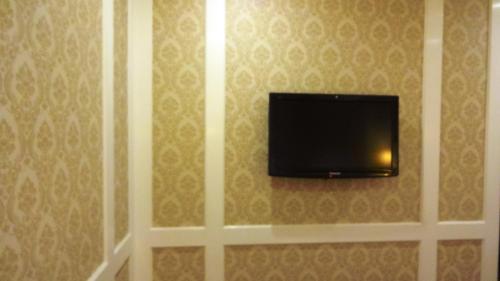 a flat screen tv hanging on a wall at Hotel Bright in New Delhi