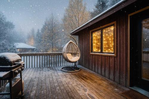 un fauteuil à bascule sur une terrasse enneigée dans l'établissement 2-Bedroom Cottage #2 - Sand Bay, à Dillon