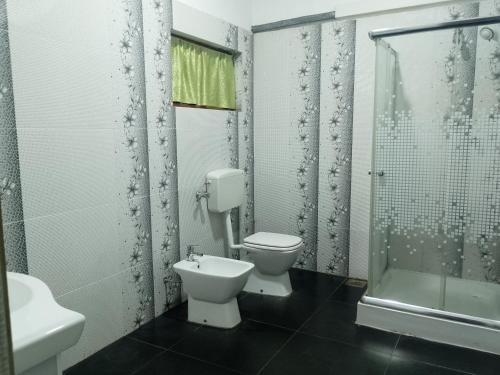 Un baño con inodoro, lavabo y ducha. en Ro Rich Hotel, en Negombo