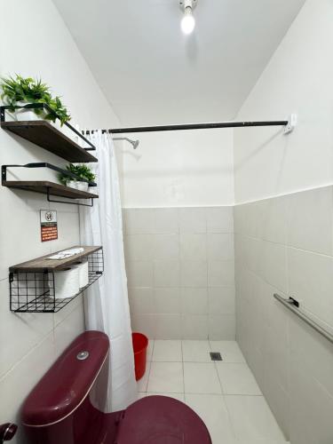 un bagno con doccia e wc viola di Seashore Inn a El Nido