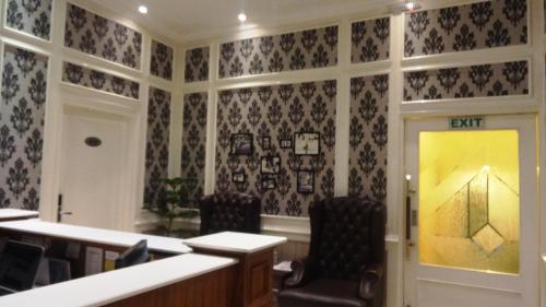 a room with black and white wallpaper and two chairs at Hotel Bright in New Delhi