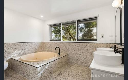 Yarra Valley farmstay - wine views في Tarrawarra: حمام مع حوض ومرحاض ونوافذ