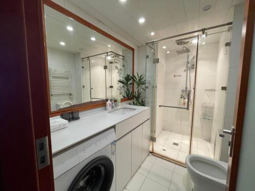 ein Badezimmer mit Waschmaschine und Dusche in der Unterkunft Beijing City center - One bedroom flat with two beds and CBD view in Peking