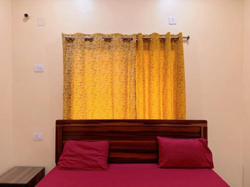 ein Schlafzimmer mit einem Bett mit einem gelben Vorhang in der Unterkunft Studio 305 Signature Heaven in Deoghar