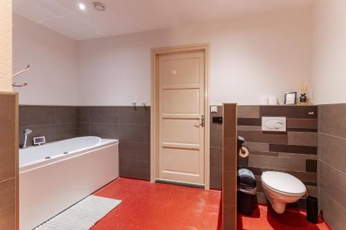 ein Badezimmer mit einer weißen Badewanne und einem WC in der Unterkunft Welcome in - Vakantiewoning Keetenweg 10 I Met airco en omheinde tuin in Stavenisse