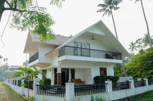 a white house with a fence in front of it at Paradise Riviera in Ernakulam