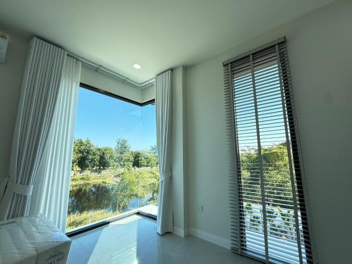una camera da letto con una grande finestra con vista di พูลวิลล่าบุรีรัมย์ a Ban Krasang