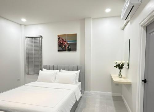 una camera da letto bianca con un letto e un tavolo di พูลวิลล่าบุรีรัมย์ a Ban Krasang
