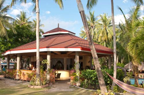 a resort with a pool and palm trees at Polaris Beach and Dive Resort Inc in Loon