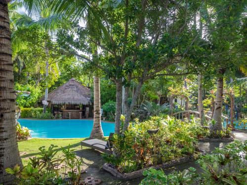 a resort with a swimming pool and trees at Polaris Beach and Dive Resort Inc in Loon