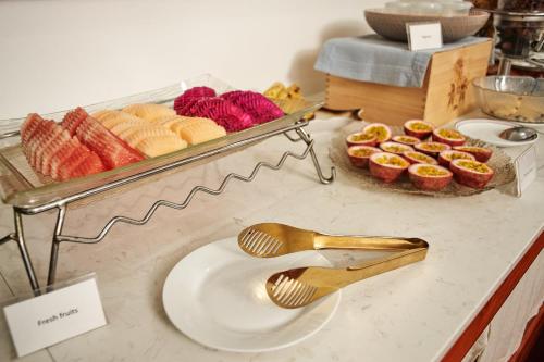 Un buffet con un plato y algunos pasteles en un mostrador. en Le Charme Vientiane Hotel, en Vientiane