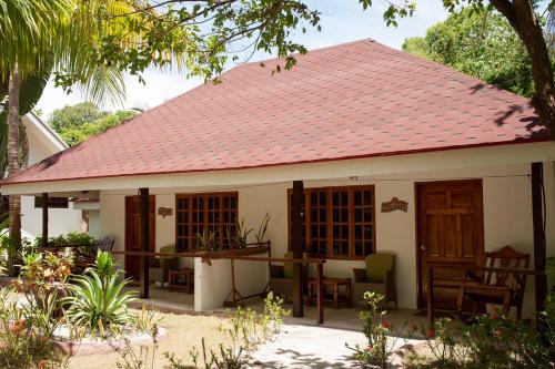 a small white house with a red roof at Polaris Beach and Dive Resort Inc in Loon