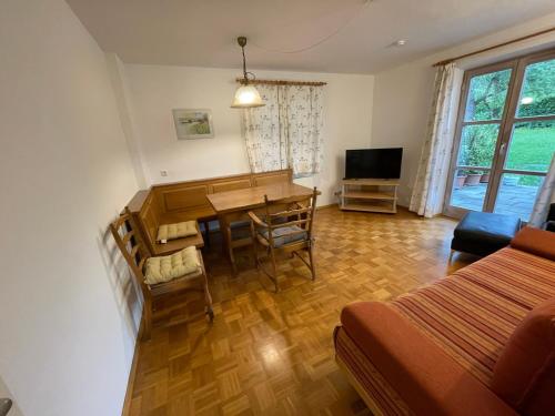 a living room with a dining room table and a bed at Ferienwohnung Maslanka EG in Utting am Ammersee