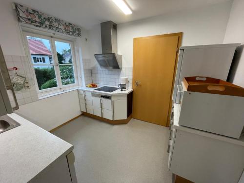a small kitchen with a refrigerator and a window at Ferienwohnung Maslanka EG in Utting am Ammersee