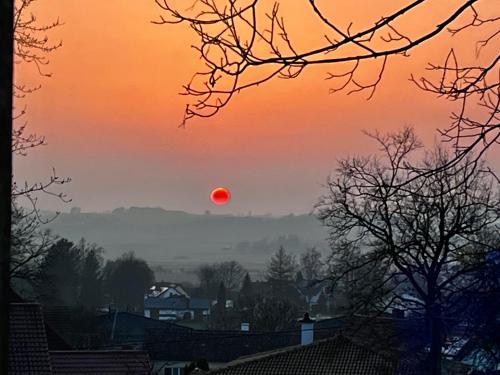 Un tramonto con un sole rosso nel cielo di Ferienwohnung Kugler a Grafrath