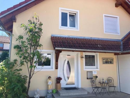 une maison avec une table et des chaises devant dans l'établissement Ferienwohnung Monika, à Eching