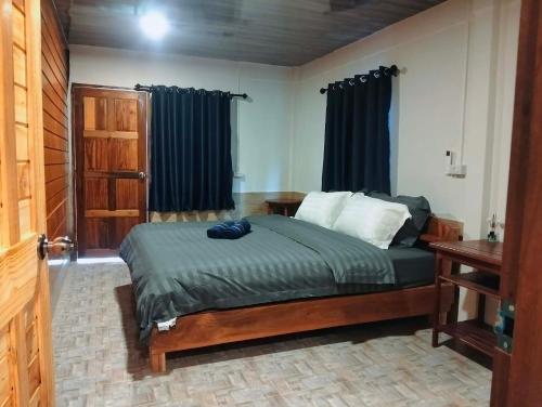 a bedroom with a bed and a window with curtains at Koh jum Mutu Home Stay in Ban Ko Phrao