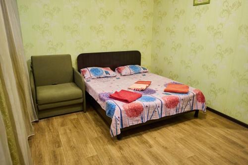 Apartment in the city centr Bursatsky descent في خاركوف: غرفة نوم صغيرة بها سرير وكرسي