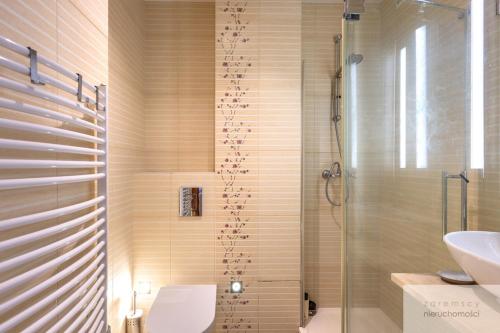 a bathroom with a shower with a toilet and a sink at Śliska Residence in Warsaw