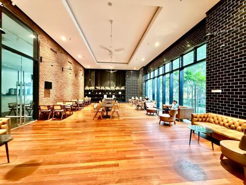 een grote kamer met tafels, stoelen en ramen bij Chambers Klcc Suites Esten in Kuala Lumpur